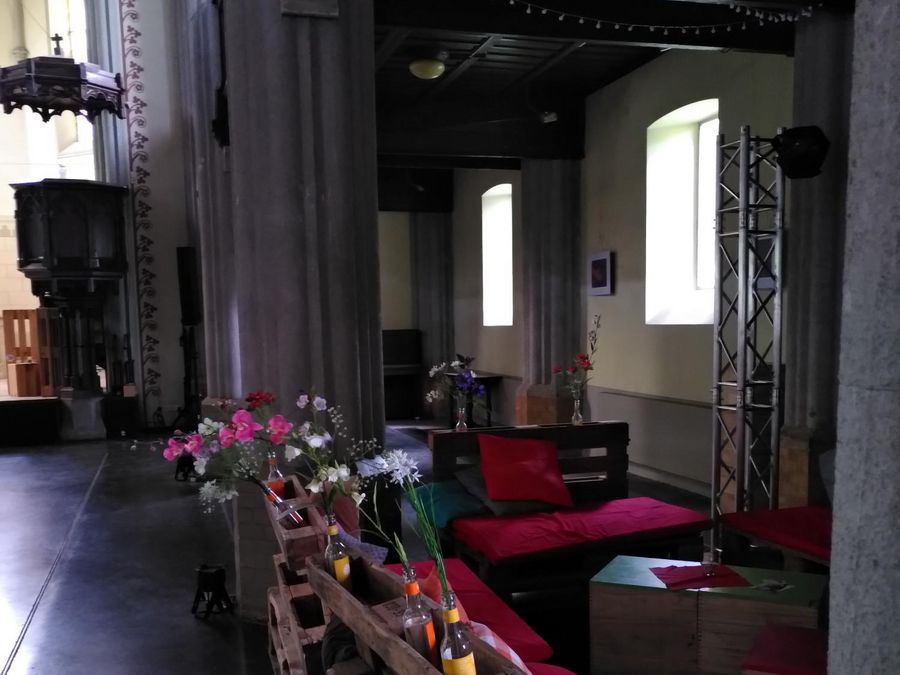 Palettencafé in der Jugendkirche PAX mit Kissen und Blumen, seitlich die Kanzel