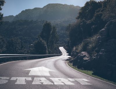 Eine Straße führt in die Berge, auf ihr das Wort "Start".