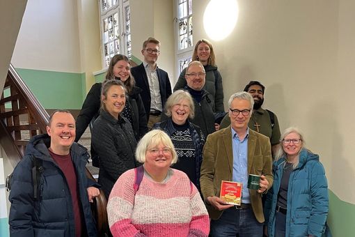 Gäste aus Edinburgh stehen für Gruppenfoto auf Treppe in der Fakultät