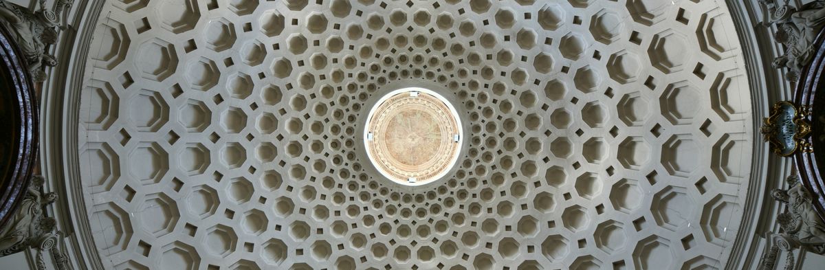 zur Vergrößerungsansicht des Bildes: Das Foto ist direkt unter der Kuppel der Kirche San Bernardo alle Terme in Rom aufgenommen. Man sieht in der Kuppel nach oben hin kleiner werdende Kreise. In diesen Kreisen sind viele Sechsecke. 