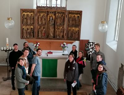 Seminarteilnehmer:innen stehen vor dem Altar in dir Schlosskirche Leipzig-Lützschena