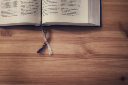 Tisch mit einem Ausschnitt einer aufgeschlagenen Bibel