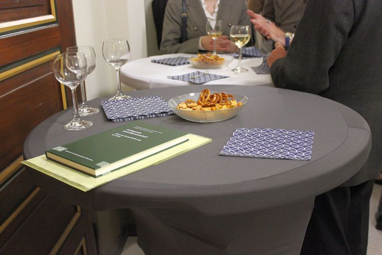 Stehtisch mit Knabbereien und der Festschrift darauf